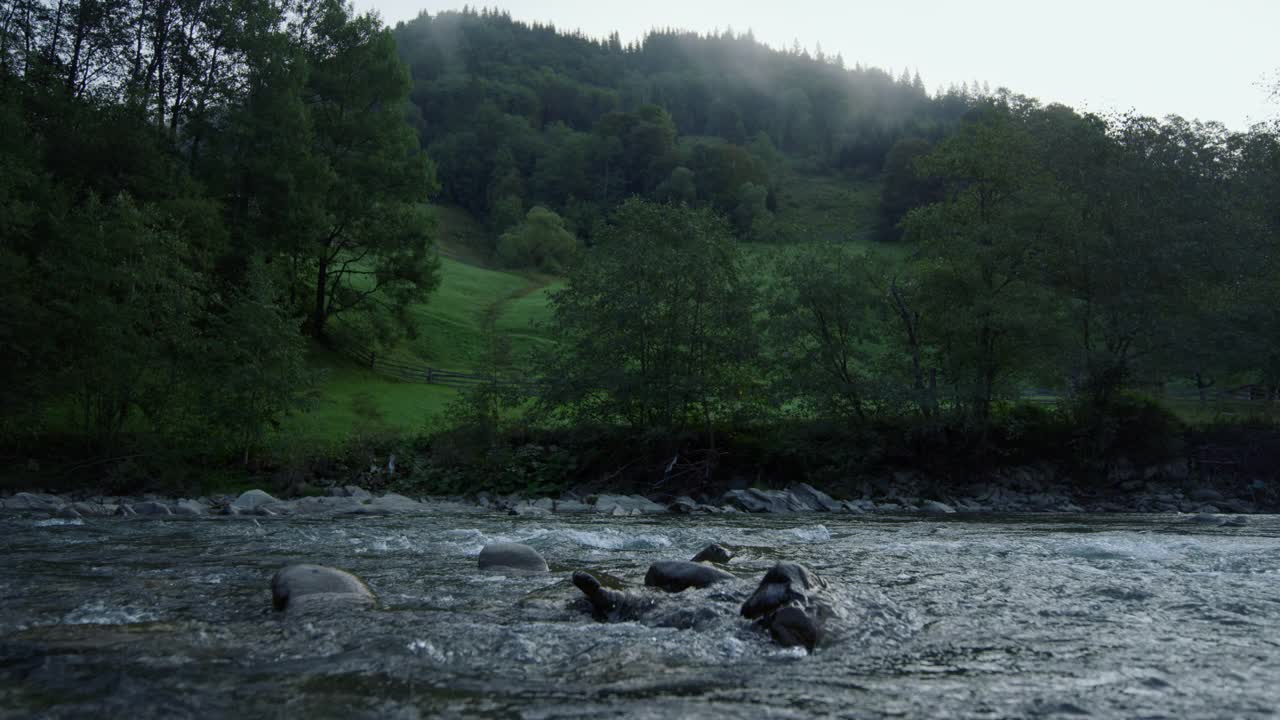 湍急的水流穿过石滩。山景，河流和森林。视频素材