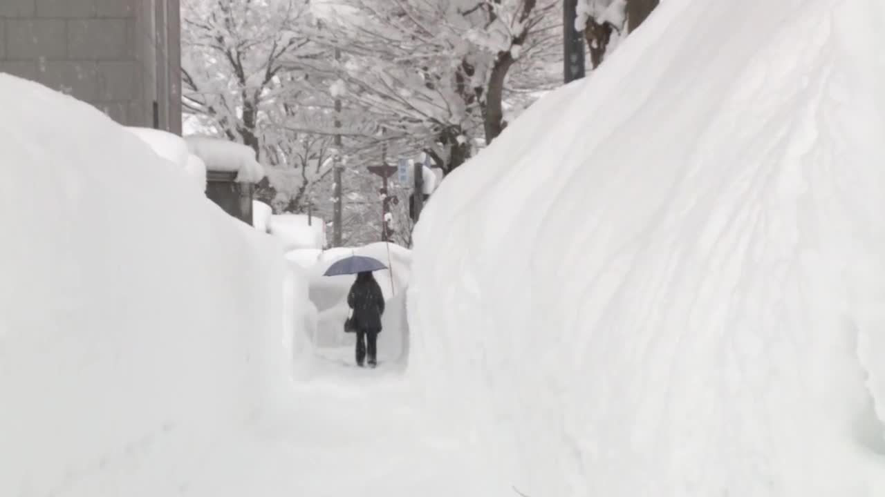 在雪墙之间行走的人，秋田，日本视频素材