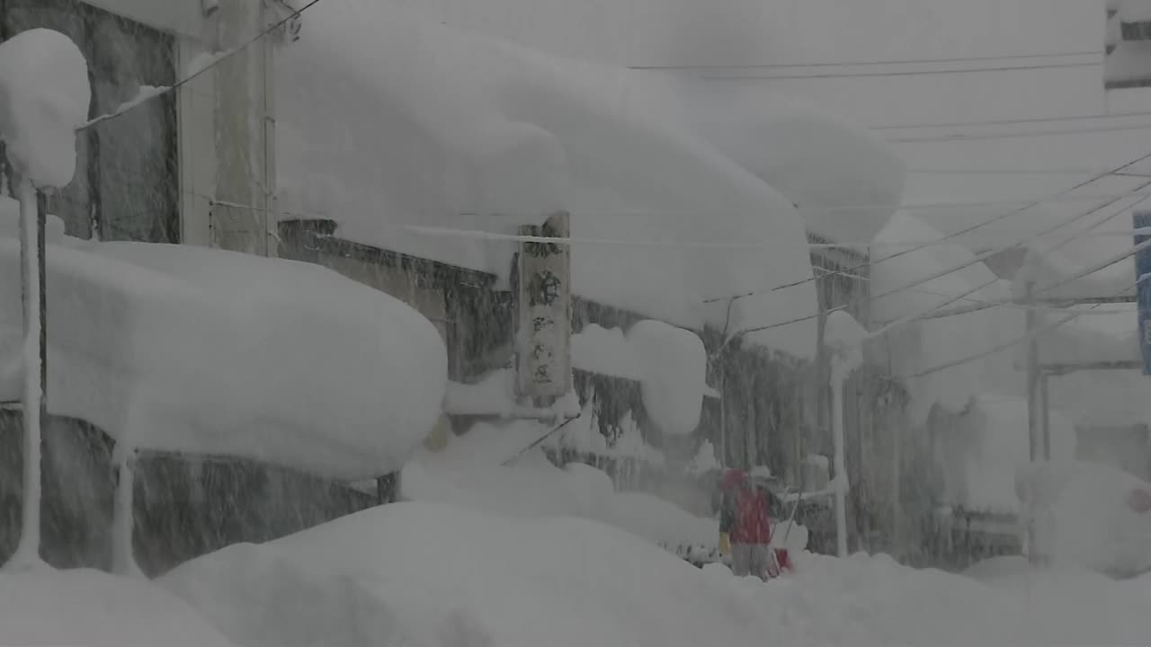 日本新泻，暴风雪中屋顶上的厚厚的雪视频素材