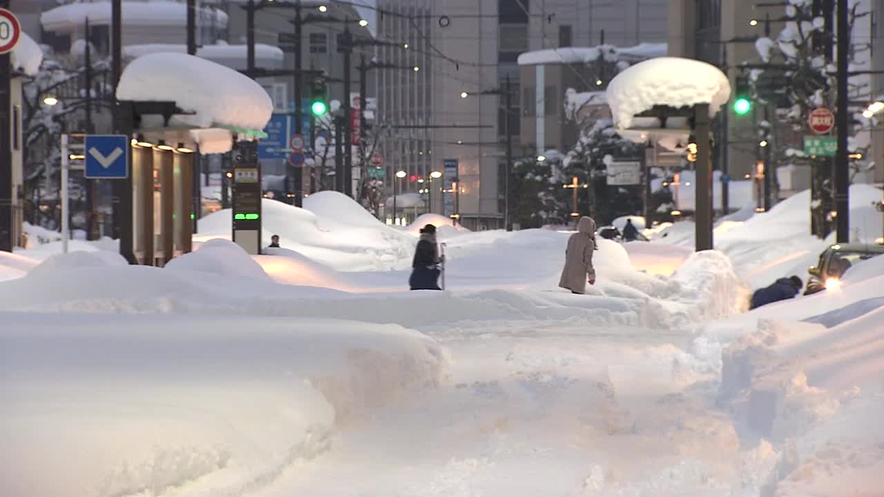 日本富山，大雪中穿过马路的人们视频素材