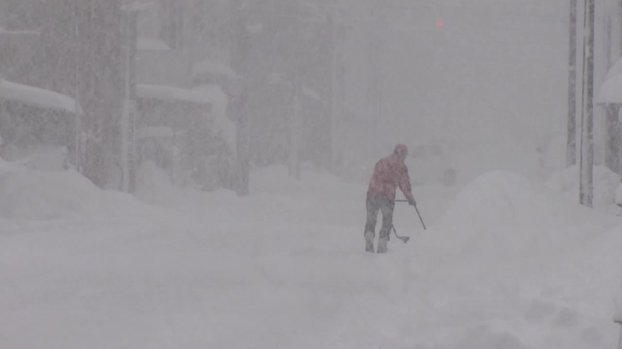 日本福井，在暴风雪中清理积雪的人视频素材