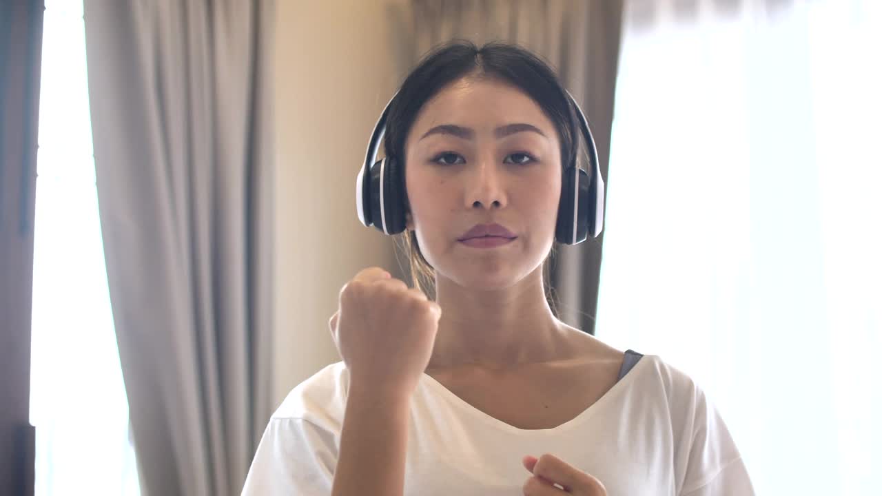 女人用拳头在空中挥拳，在家训练视频素材