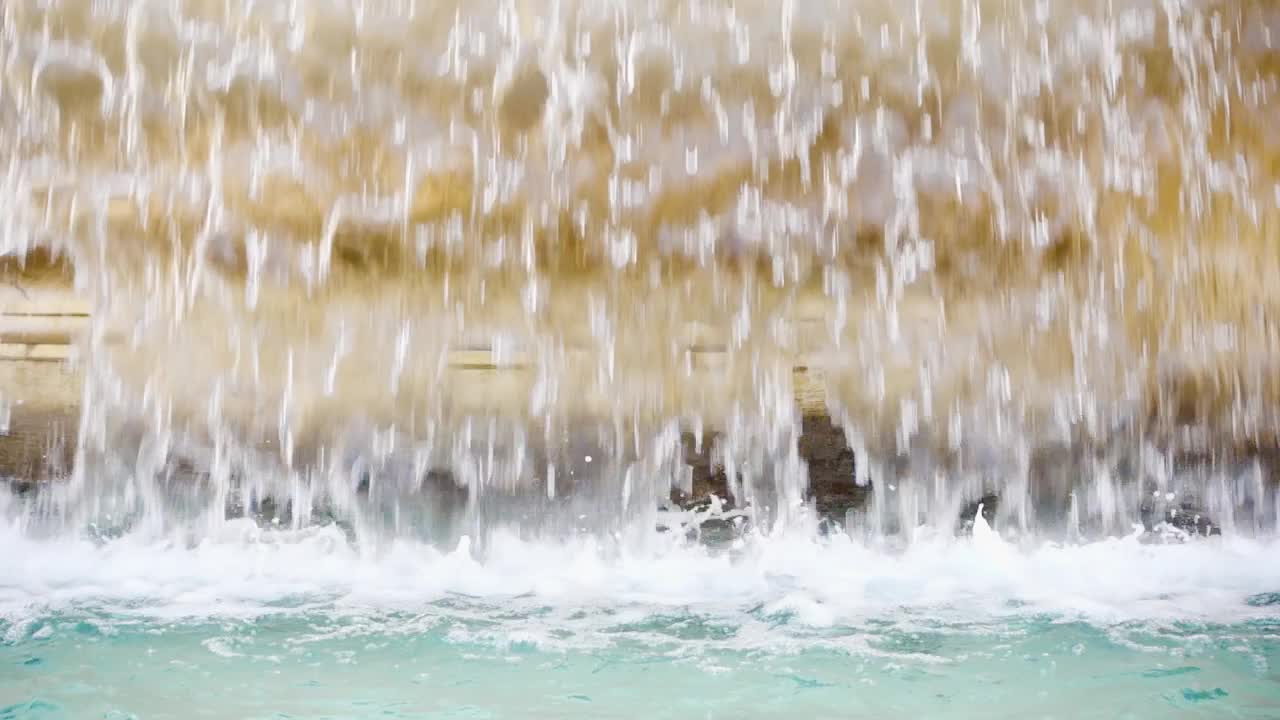 老黄大理石喷泉水幕的特写。透明的水流。夏天阳光灿烂的日子视频素材