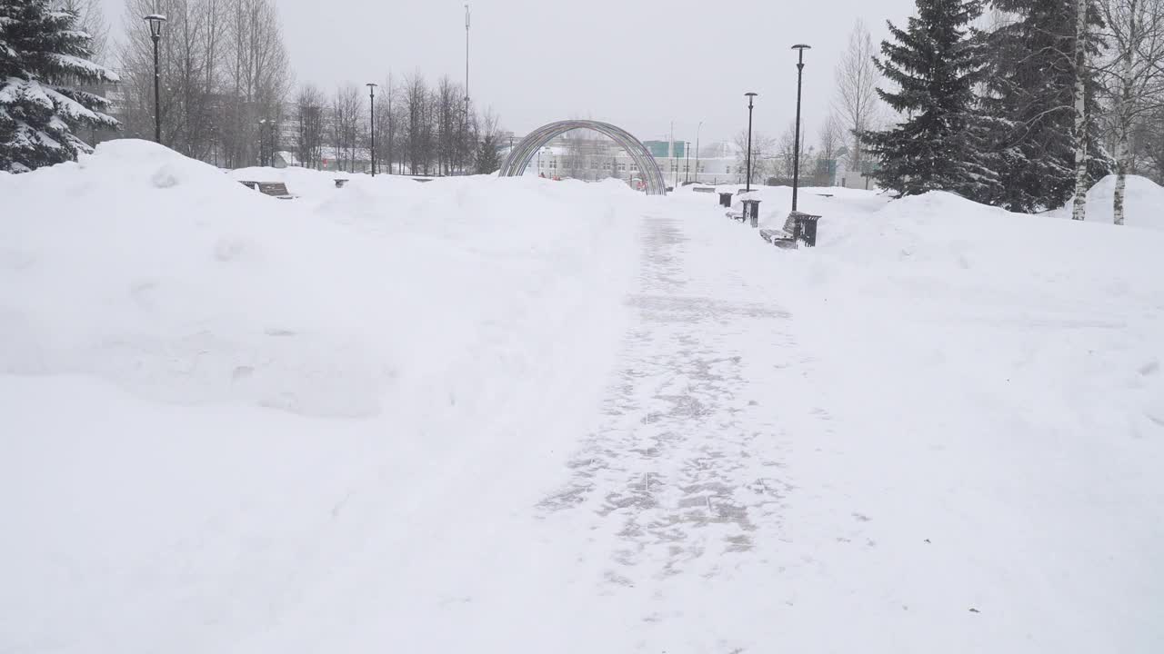 一场大雪过后，在莫斯科城市住宅区清理公园的小路视频素材