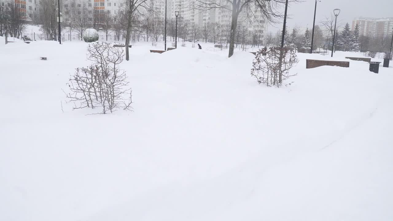 一场大雪过后，在莫斯科城市住宅区清理公园的小路视频素材