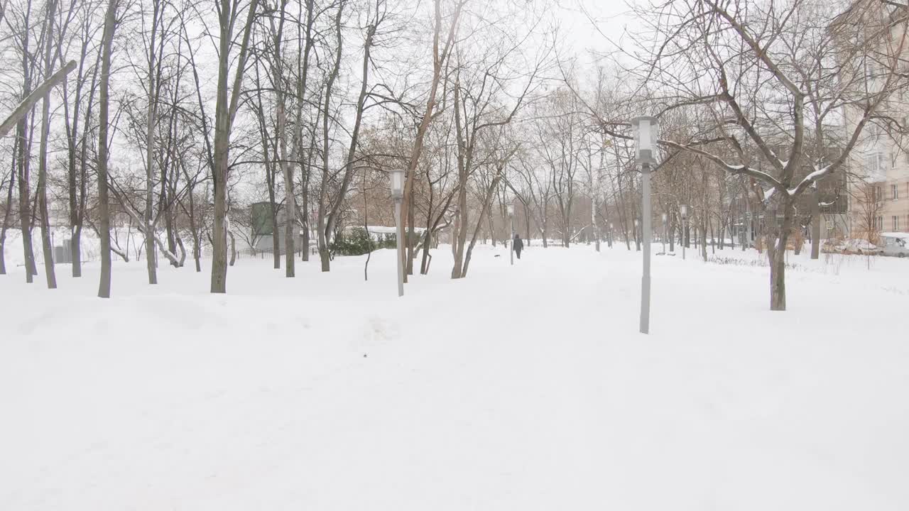 一场大雪过后，在莫斯科城市住宅区清理公园的小路视频素材