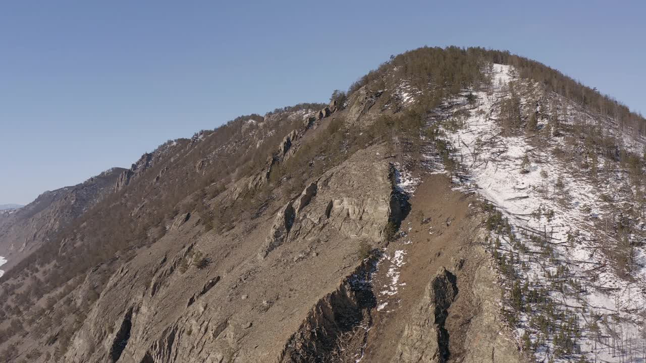 飞绕着白雪覆盖的岩石山峰。视频素材