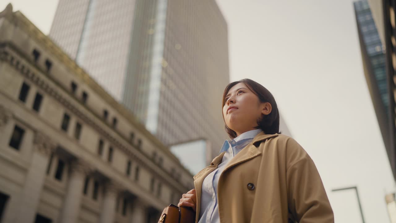 低角度视频肖像的年轻和自信的女商人高楼大厦在金融区视频素材