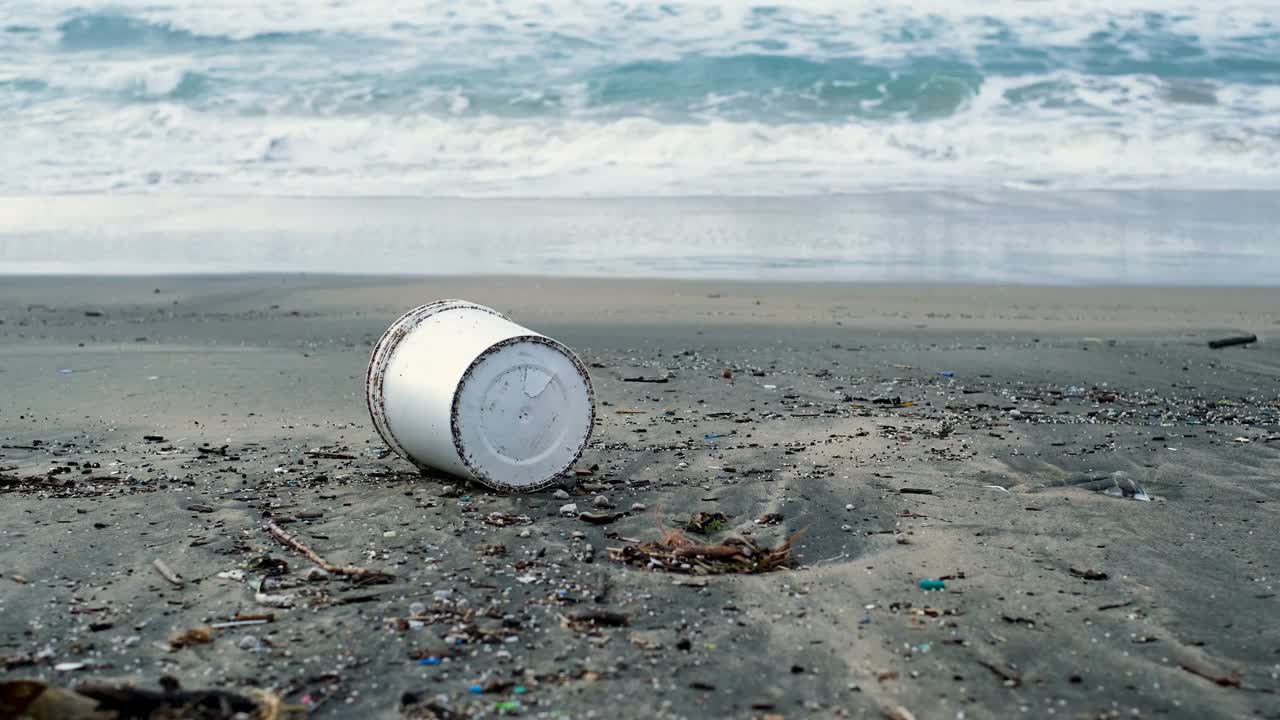 塑料容器废弃物和焦油污染在暴风雨的海岸，环境视频素材