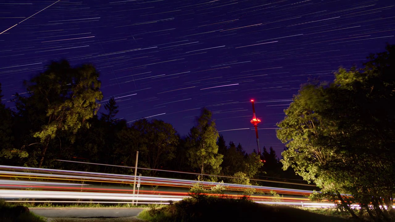 移动的星星和星迹在德国森林与红色照明的无线电塔晚上视频素材