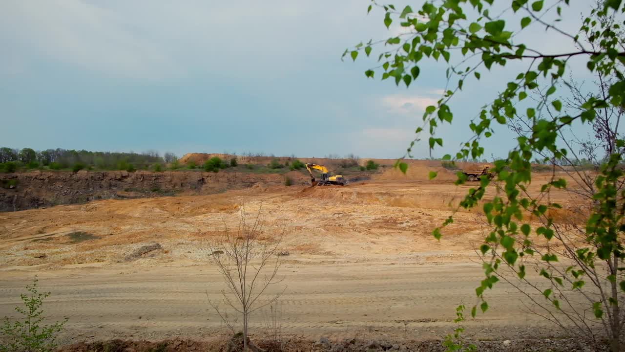 矿山建设行业。大型黄色挖掘机在采石场搬运石头视频素材