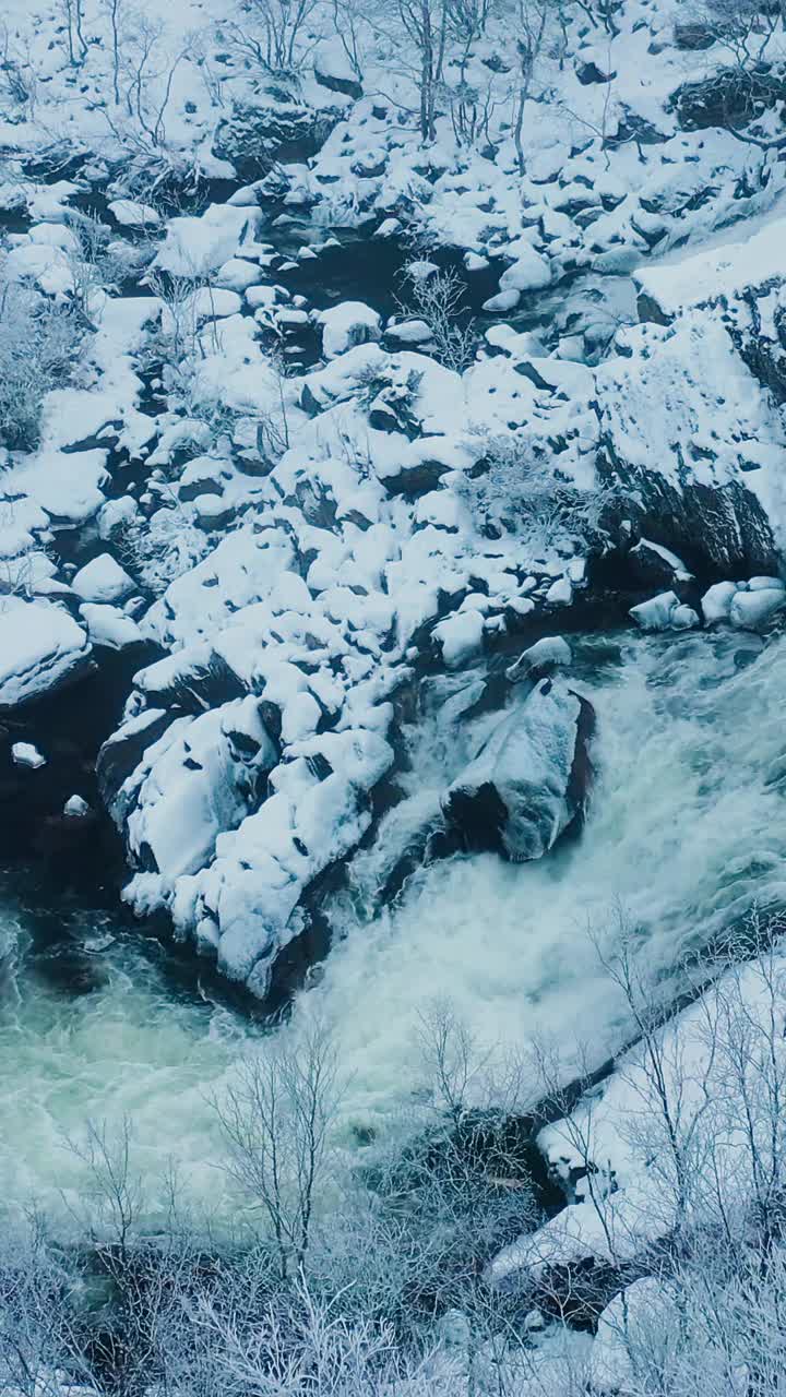 鸟瞰图，暴风雨的山河在冰雪覆盖的岩石土壤中流动视频素材