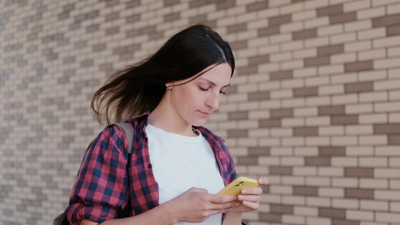 美丽的女孩在户外用智能手机查看社交网络。学生在城市公园休息视频素材