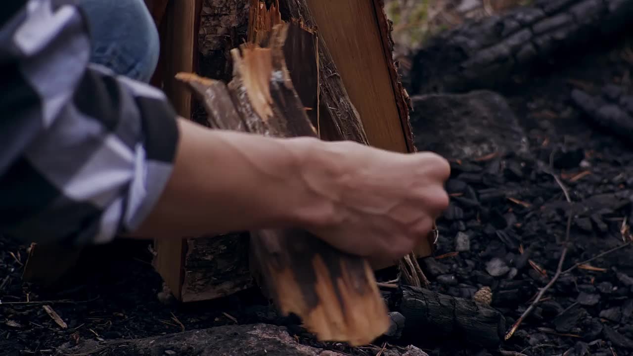 年轻的旅行者在森林中拾柴生火。手与结婚戒指靠近。露营。在山里远足。旅游业。旅行视频下载