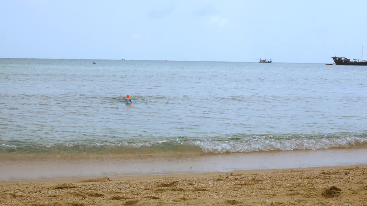 一个戴着面具在海滩上潜水的人视频素材