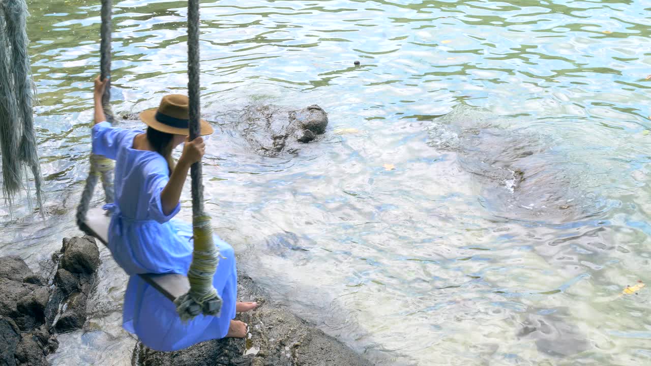 漂亮的年轻女士在热带海滩上荡秋千视频素材