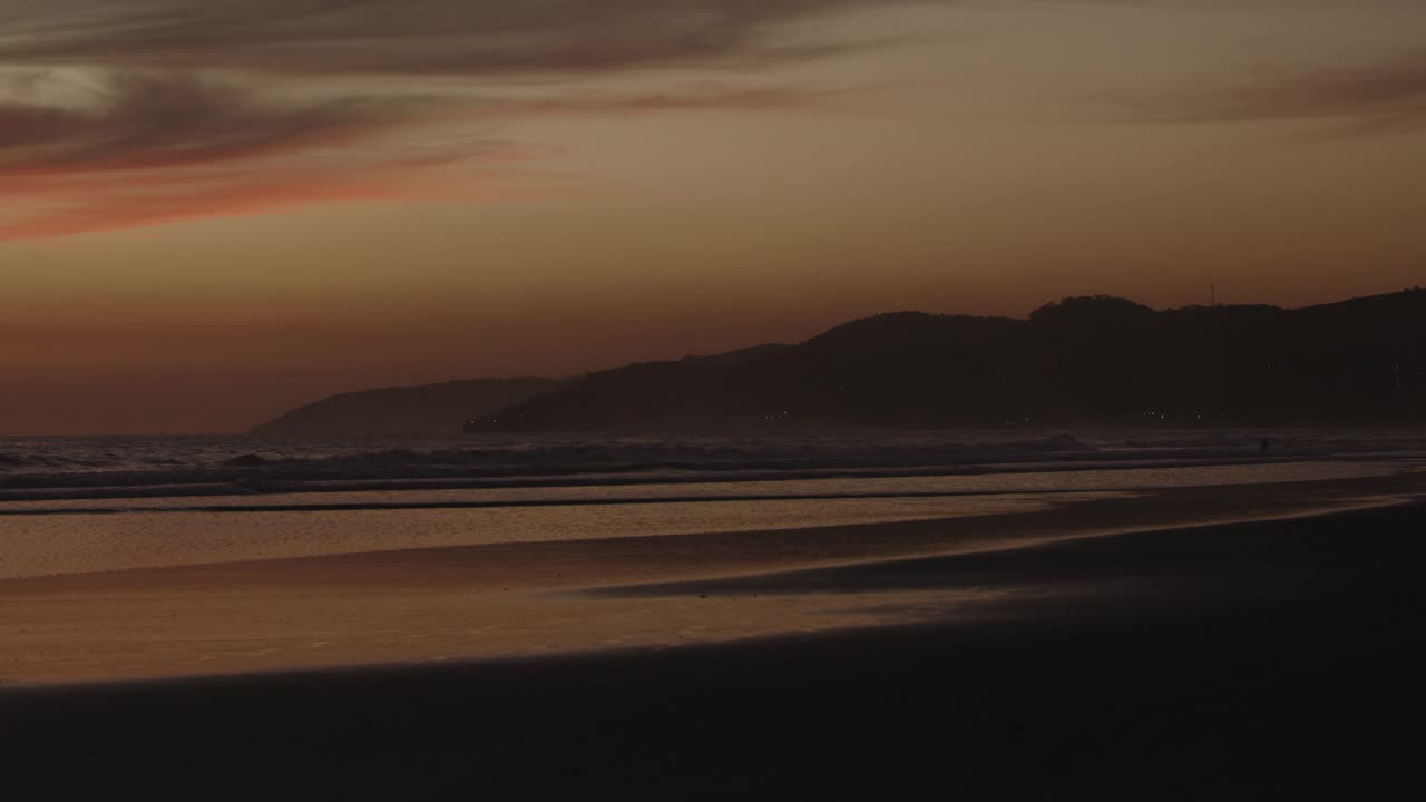 宽镜头拍摄海滩上的海浪在日落/圣布拉斯，拉利伯塔德，萨尔瓦多视频素材