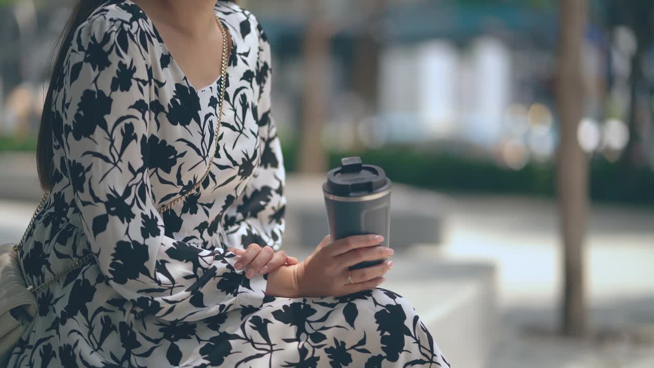 特写亚洲女人用可重复使用的旅行杯喝咖啡。视频素材