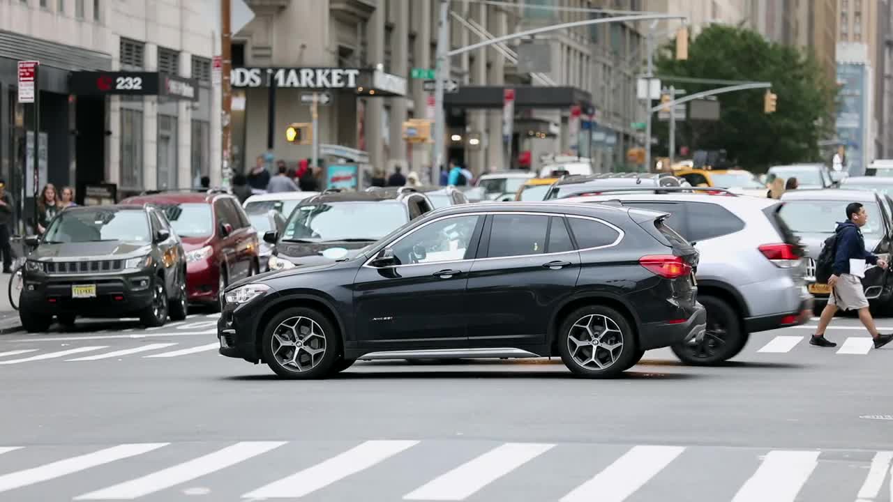 纽约曼哈顿，人们在尖峰时间过马路。卡车，出租车，公共交通，出租车背景视频素材