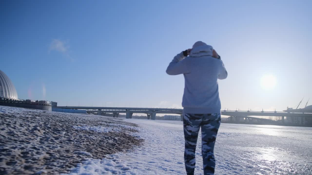 女孩在冬天沿着白雪覆盖的沙滩跑步视频素材