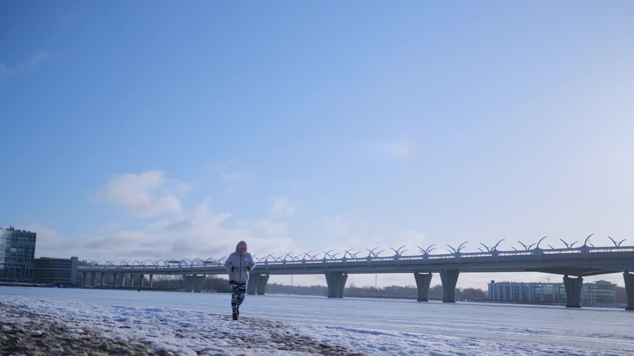 女孩在结冰的河上慢跑视频素材