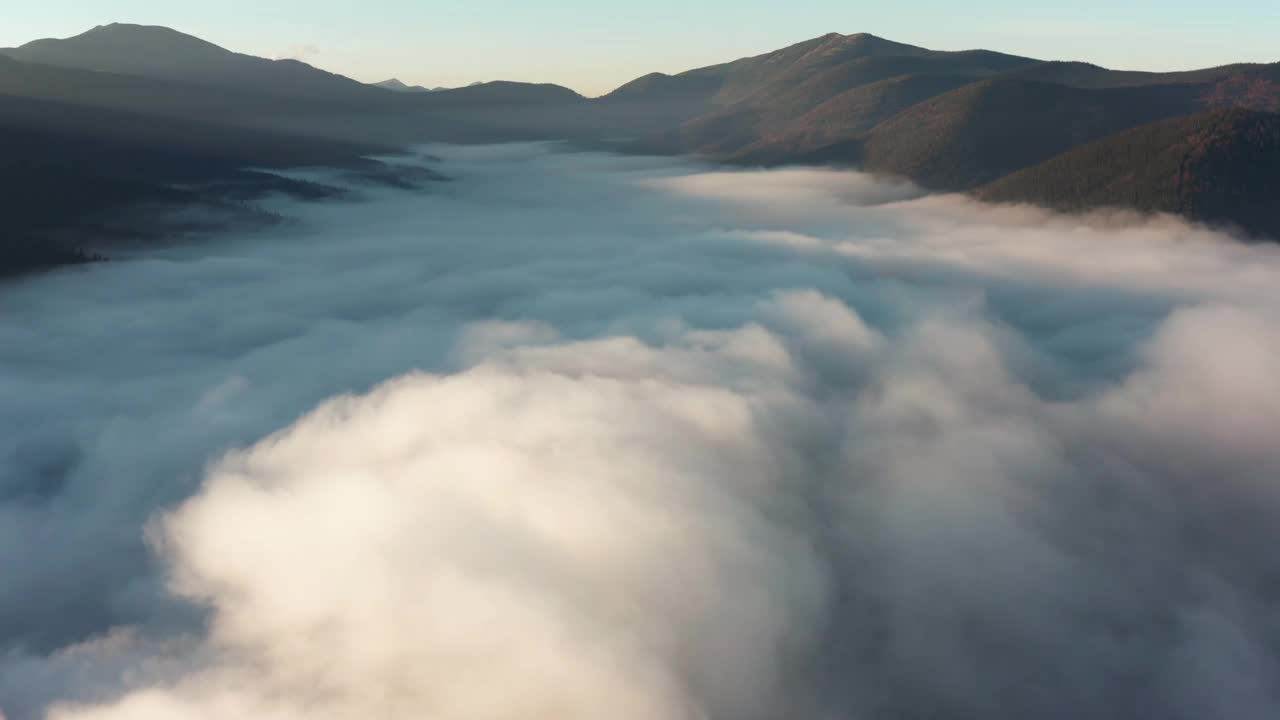 鸟瞰图的山景观与浓雾山谷在黎明。视频素材