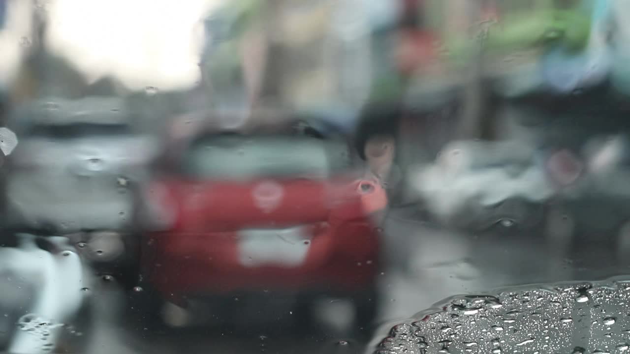 窗外的挡风玻璃看到的是模糊的雨。视频素材