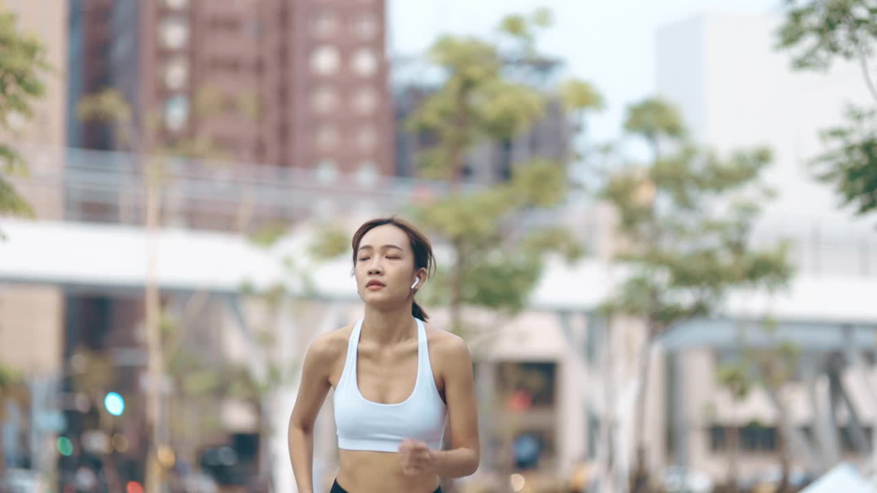 年轻女子在城市公园路上慢跑视频素材