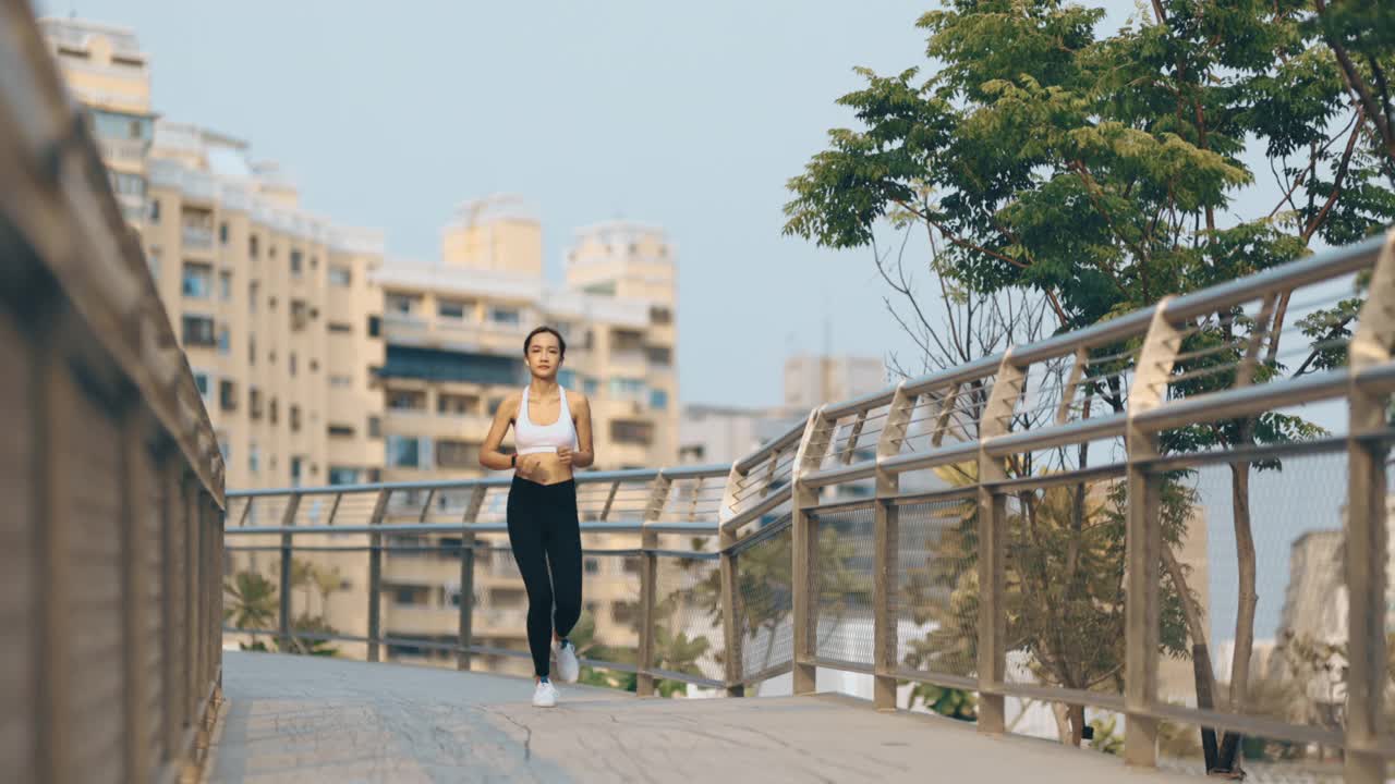 年轻女子在城市公园路上慢跑视频素材