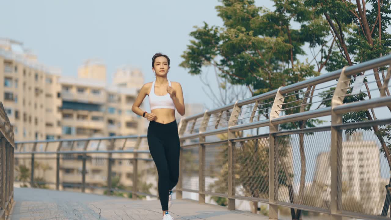 年轻女子在城市公园路上慢跑视频素材