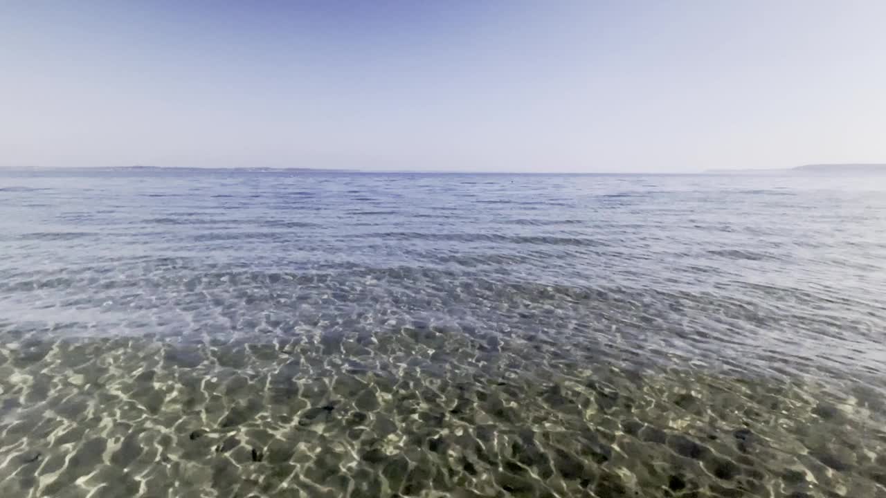 清澈的海水，波浪的波纹和飞翔的海鸥对晴空视频素材