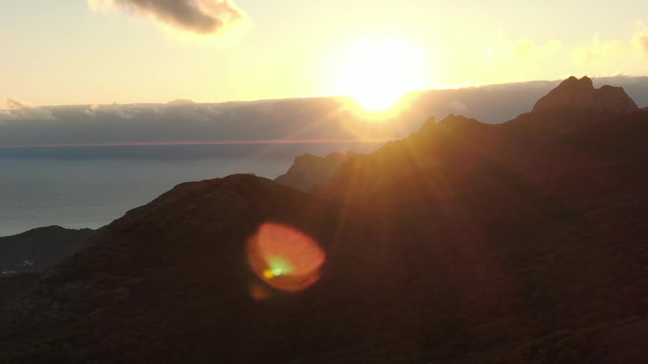 海岸山脉的背景海面与一个多云的海啸在地平线上和一个明亮的太阳在上面。视频下载