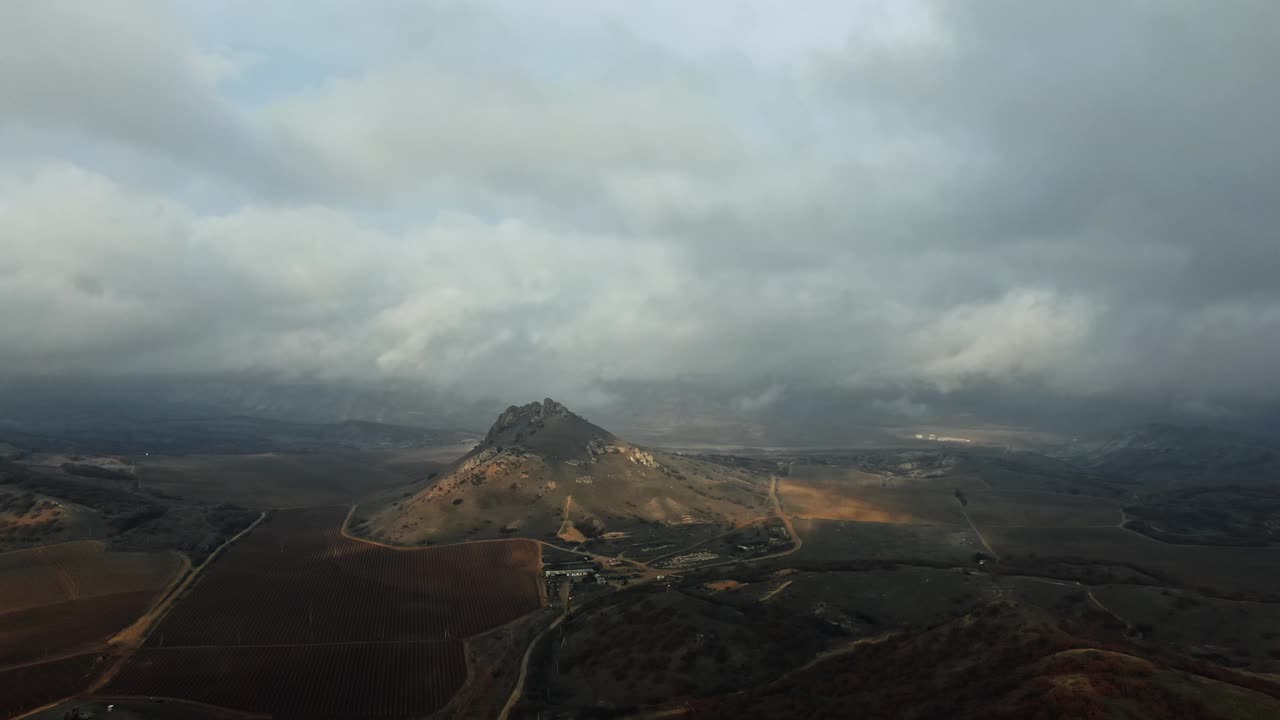 在多云的天空下，山坡上明亮的太阳黑子和山谷中的葡萄园视频下载