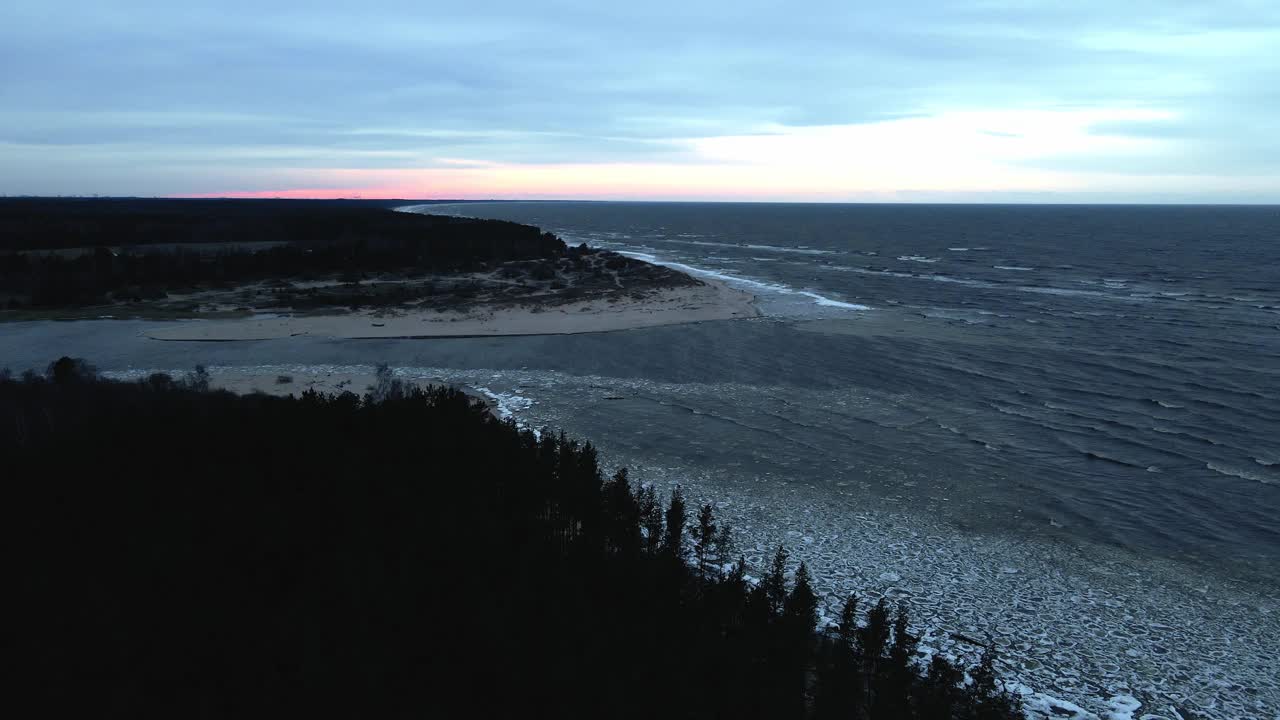 风景日落，海上和河流鸟瞰冰漂流与倒下的树在大风天气与波浪视频素材