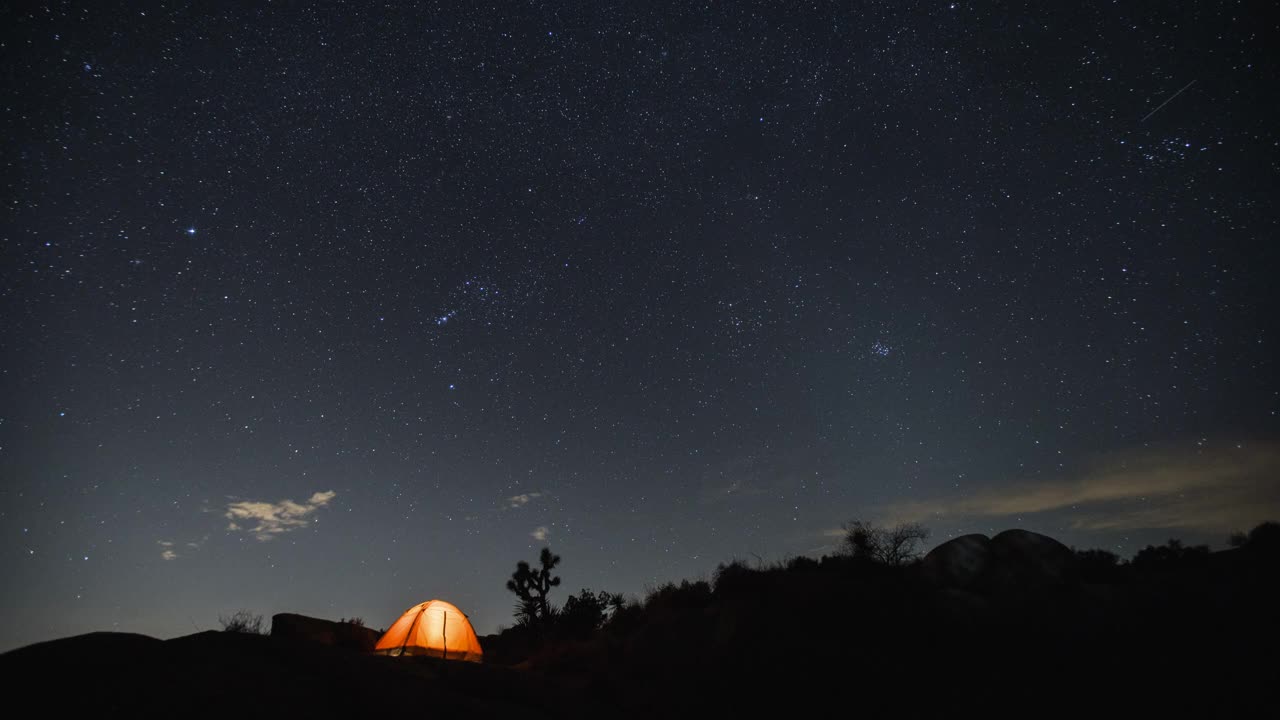 在夜晚的星空下在沙漠中露营。视频素材