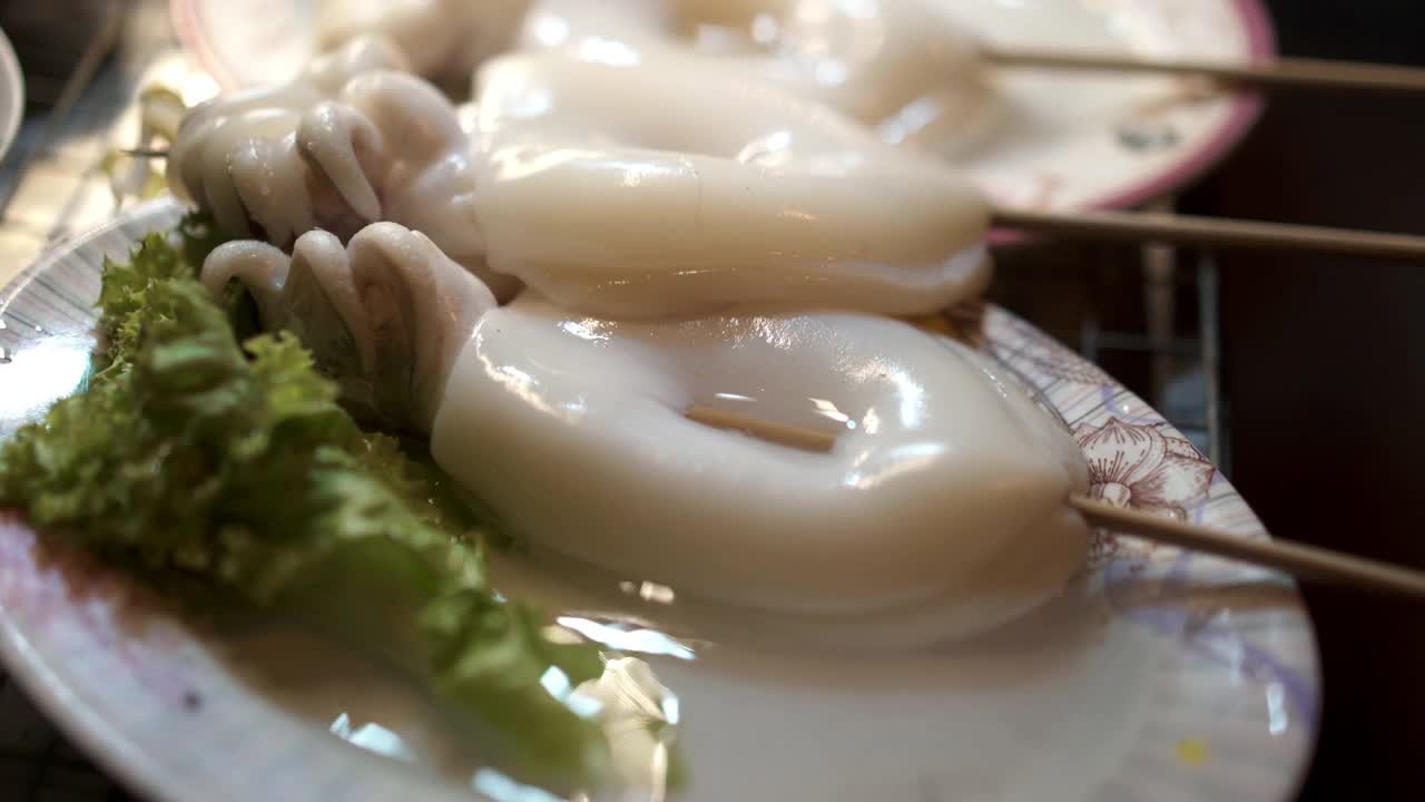 特写生鱿鱼串烤鱿鱼摊上的菜-泰国街头食品视频素材