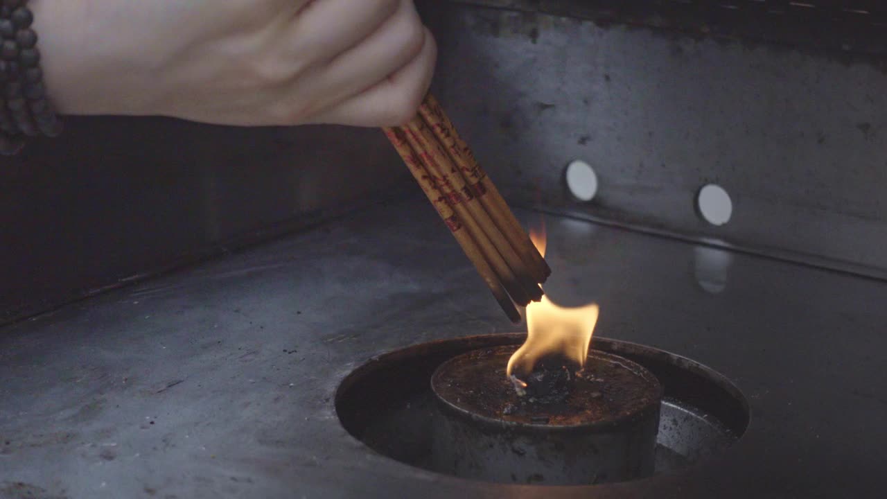 在中国香港佛寺，人们用黄色的火焰点燃香烛，祈求好运、希望和财富，这是著名的旅游和祈祷希望的地方视频下载