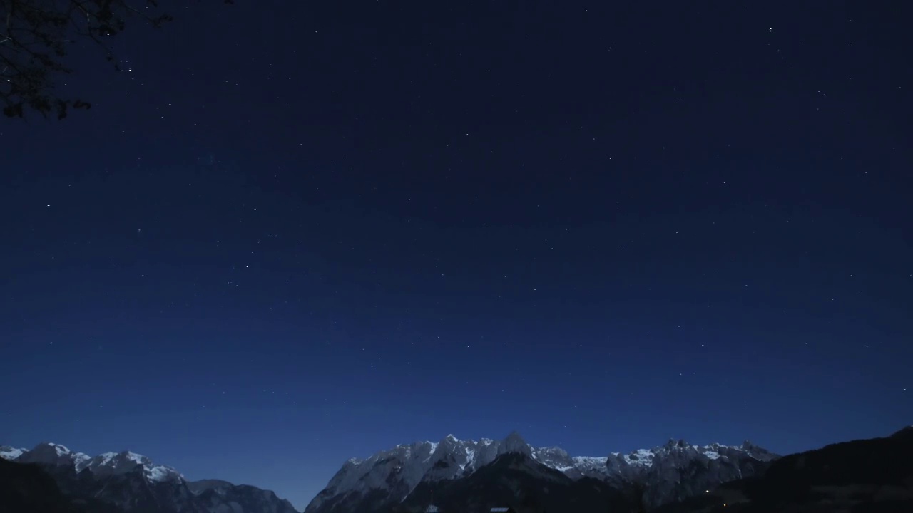 在奥地利阿尔卑斯山的一个星夜的时间流逝与雪覆盖山脉的轮廓视频下载