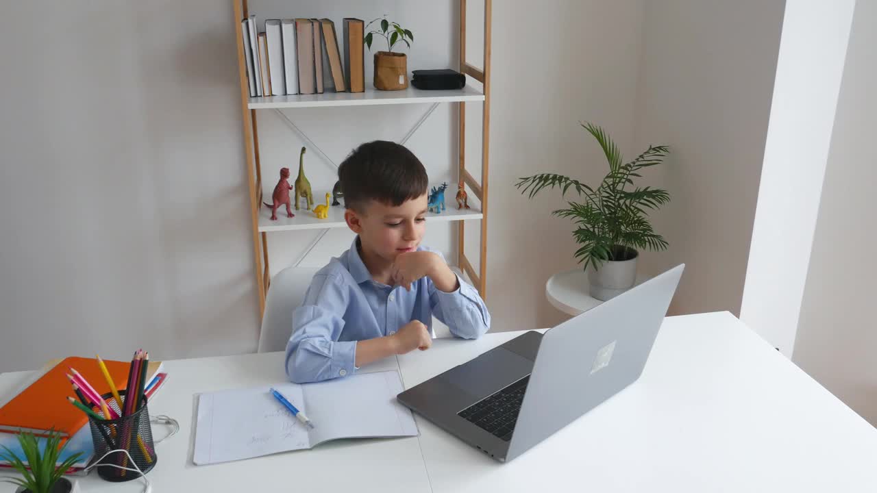 孩子在家里通过笔记本电脑与老师在线学习。小学学习视频下载