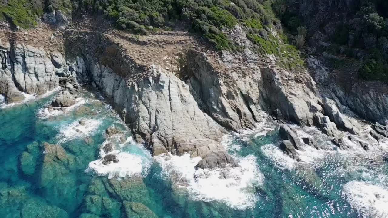 航拍视频，海浪拍打着岩石海洋悬崖，溅起白色泡沫。视频下载