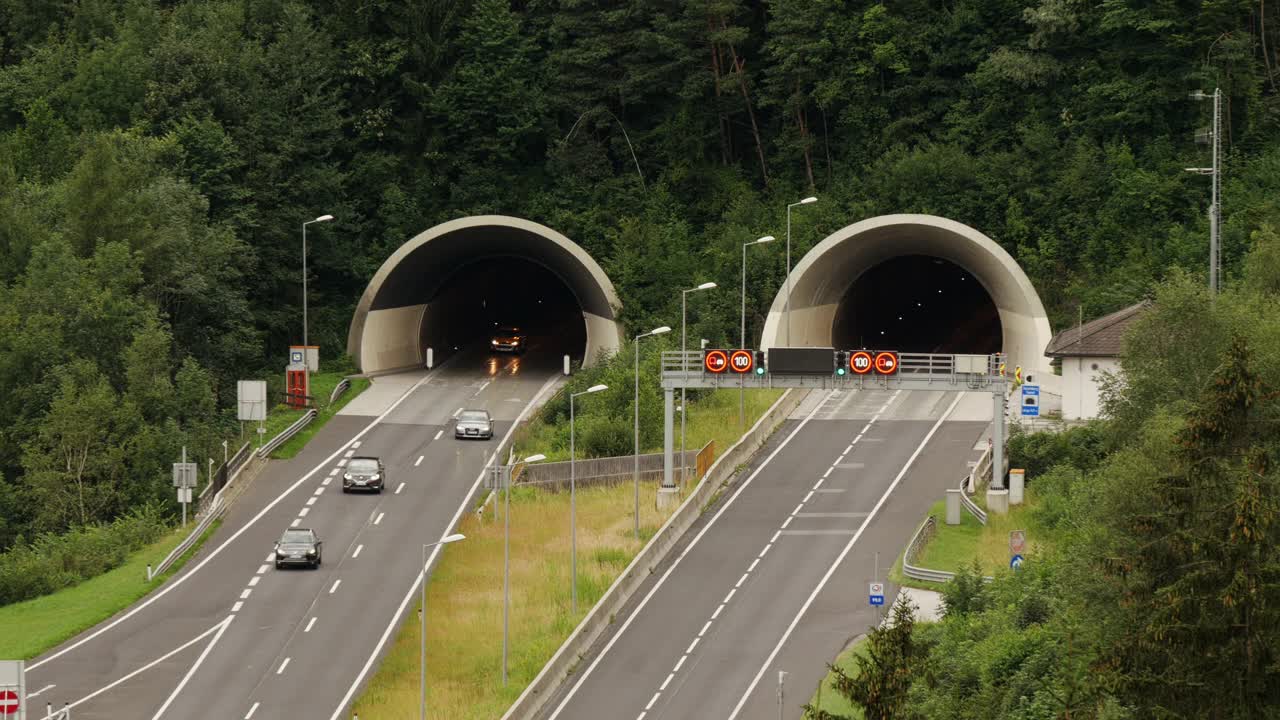 交通在高速公路隧道入口和出口在奥地利阿尔卑斯山-狭窄的镜头从上面看视频下载