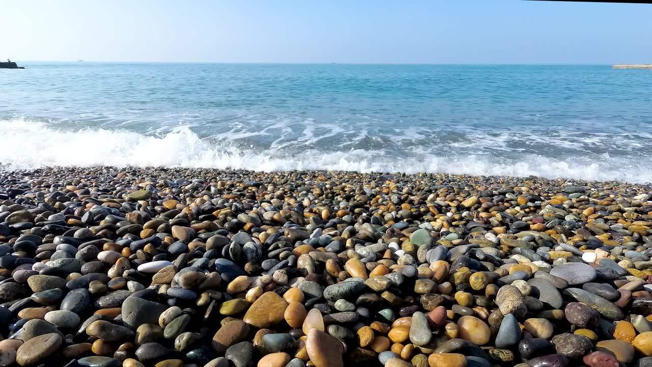 海浪冲过海岸。卵石滩。在水边度过暑假的概念视频下载