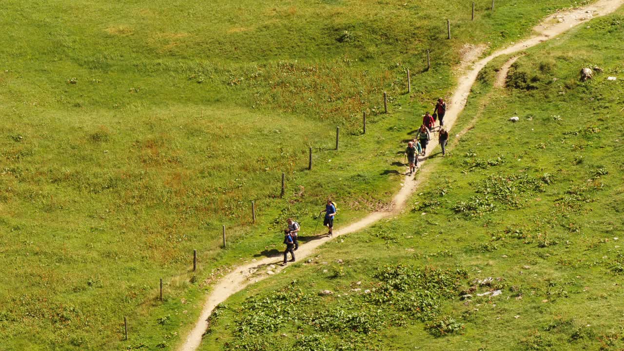 一群徒步旅行者在奥地利阿尔卑斯山塔彭卡湖的一条小路上——从上面拍摄的宽度视频下载