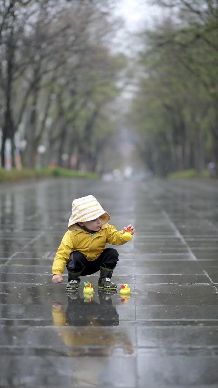 孩子们在水坑里玩橡皮鸭视频素材