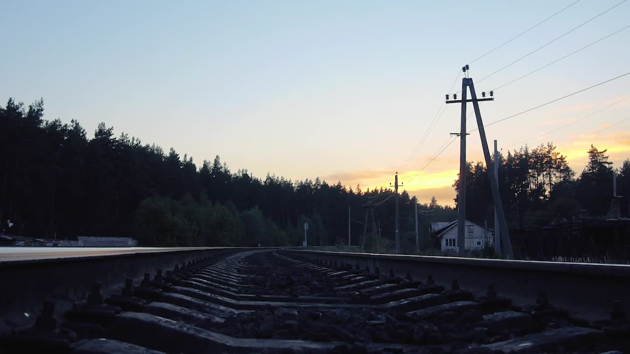 一个孤独的蒙面旅行者在夕阳下走在铁路上视频下载