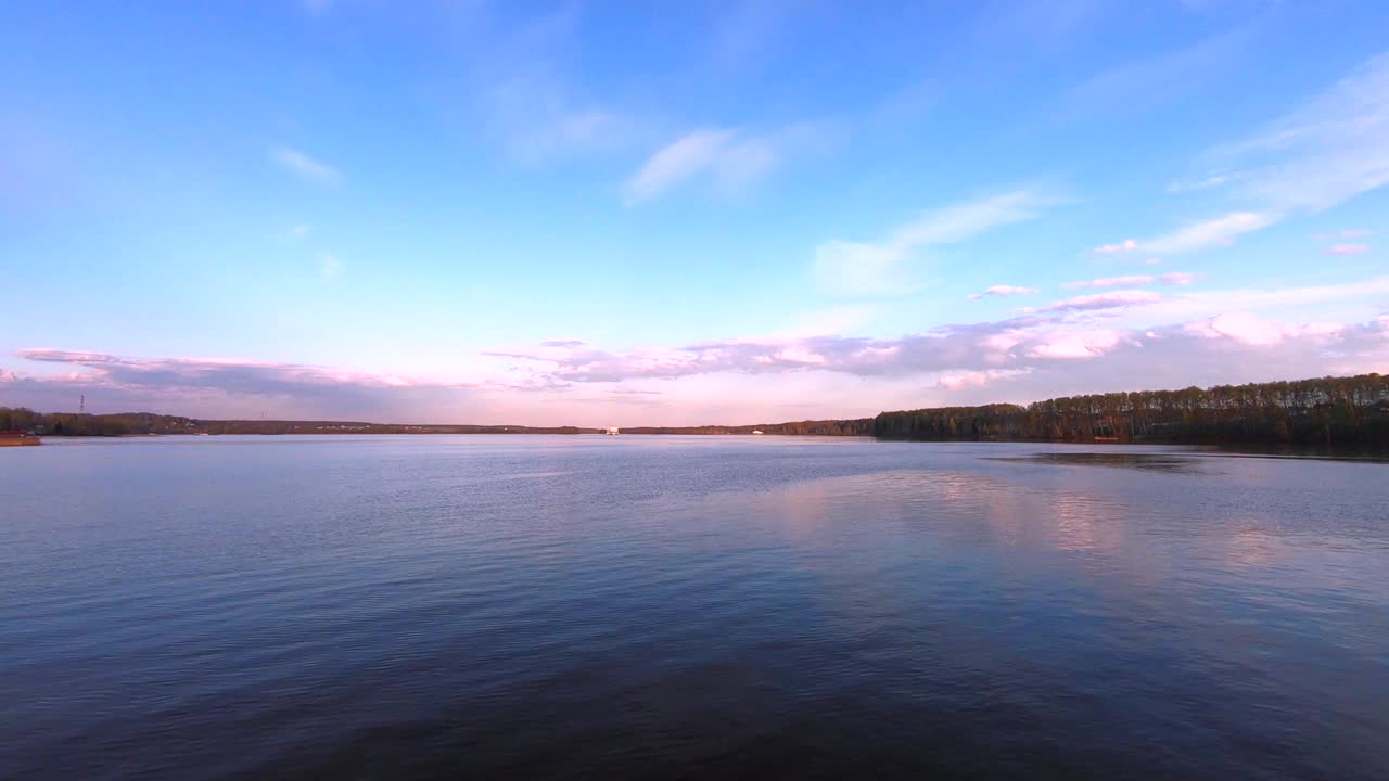 日落时分，一艘大型客轮在河上缓缓驶过。美丽多彩的风景映衬着日落时的蓝天。视频下载