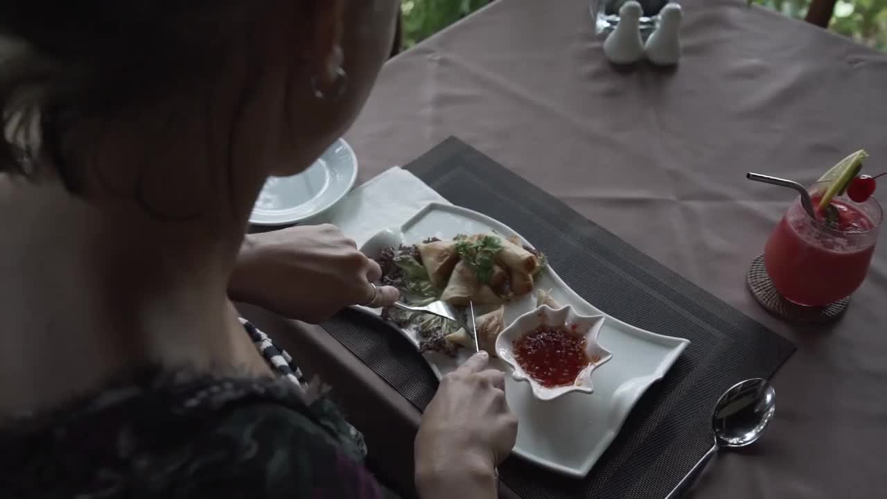 在马来西亚兰卡威的豪华度假村，女人吃健康早餐的俯视图。视频下载