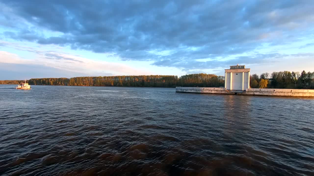 日落时分，游艇在河上驶过。美丽多彩的风景映衬着日落时的蓝天。在河上乘船旅行。视频下载