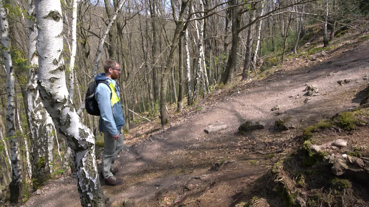 让徒步旅行者走在森林的小上坡路上视频下载