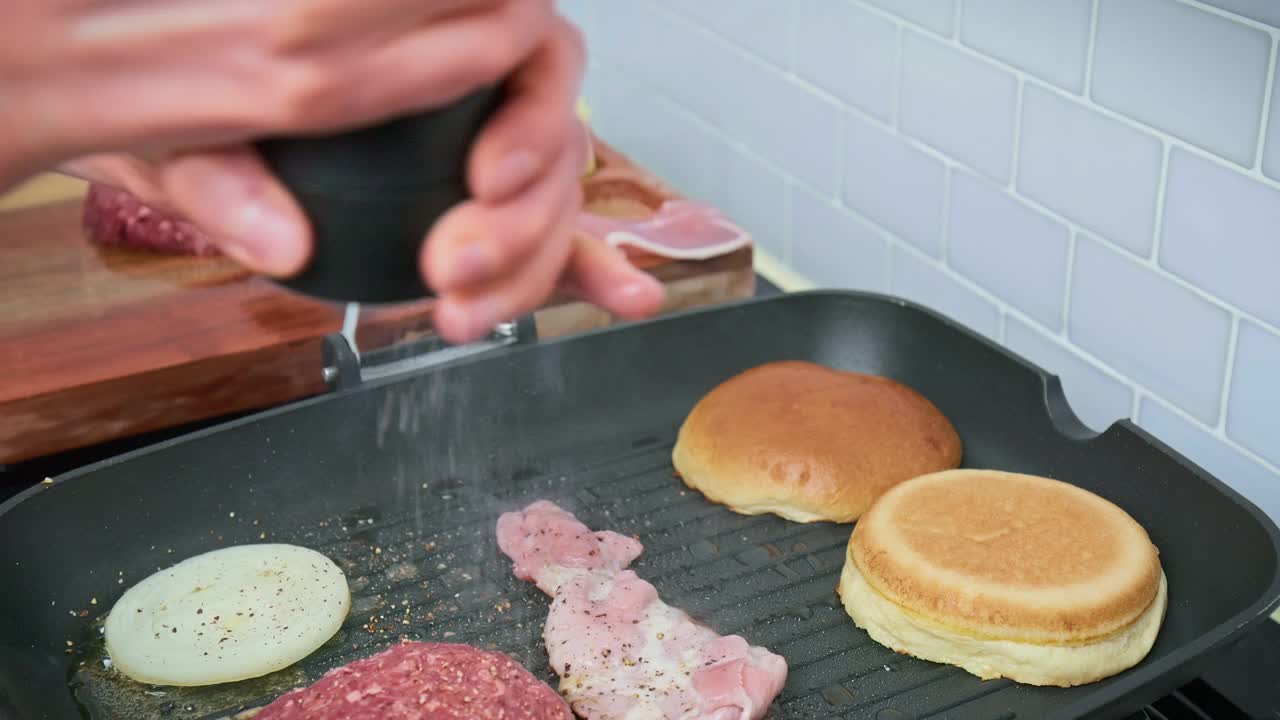 用盐和胡椒调味牛肉汉堡的原料在4K烤盘。视频下载